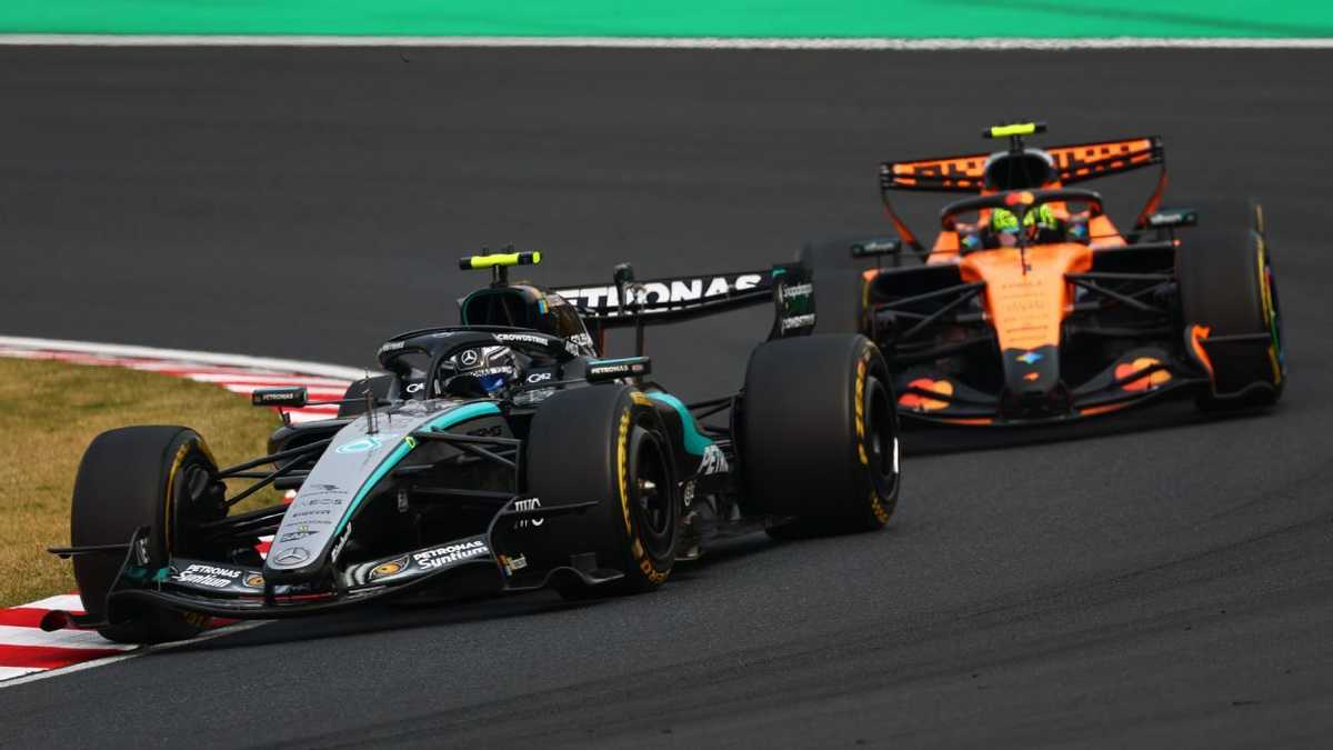 Kimi Antonelli raising his arm as he crosses the finish line with the chequered flag at Suzuka Circuit