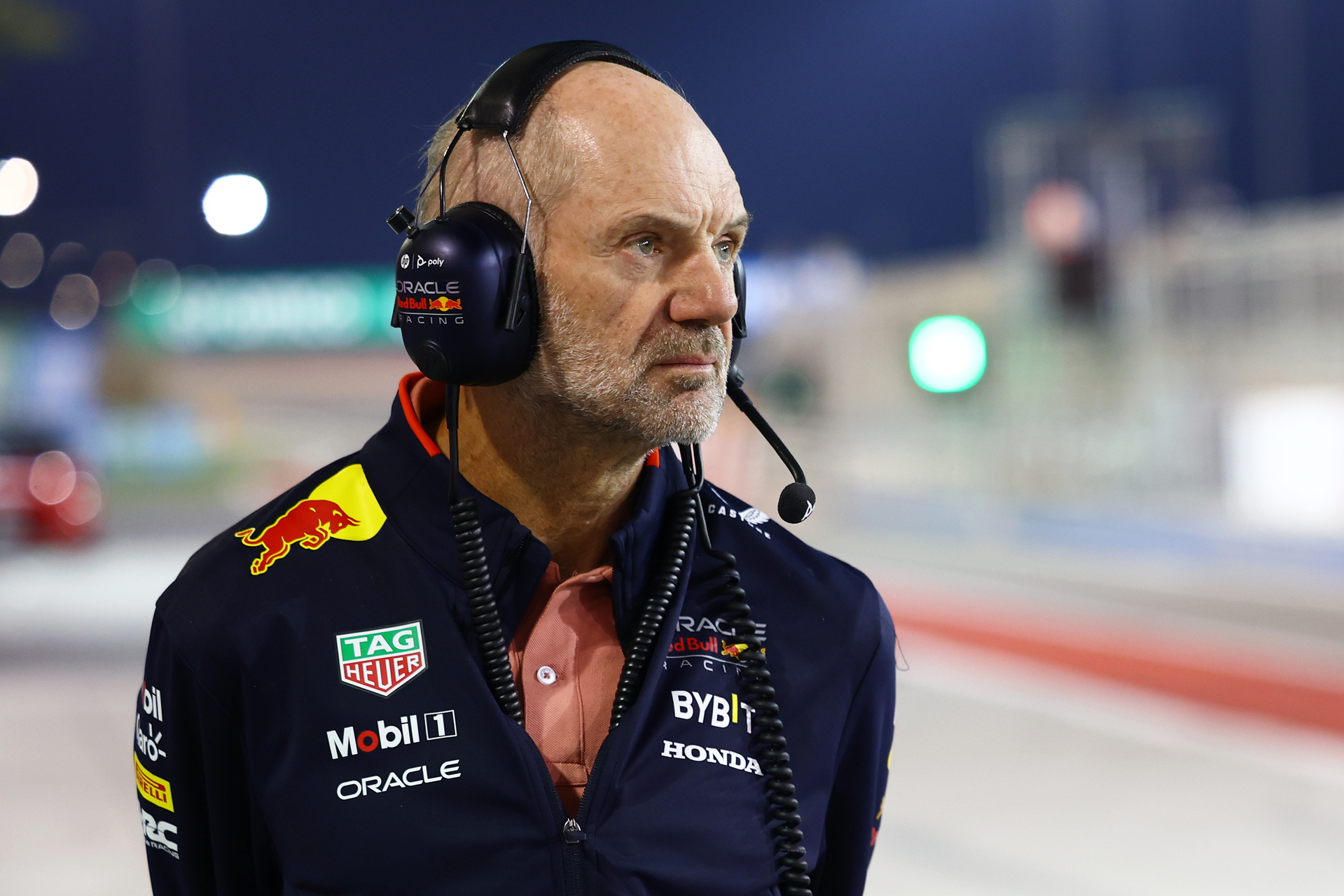 Portrait sketch of Adrian Newey in his design studio surrounded by technical drawings and aerodynamic models.