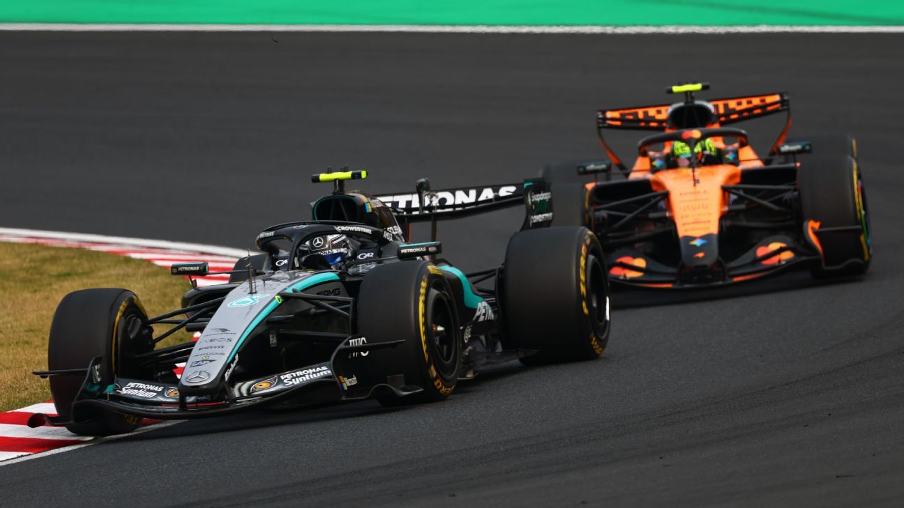 Kimi Antonelli raising his arm as he crosses the finish line with the chequered flag at Suzuka Circuit
