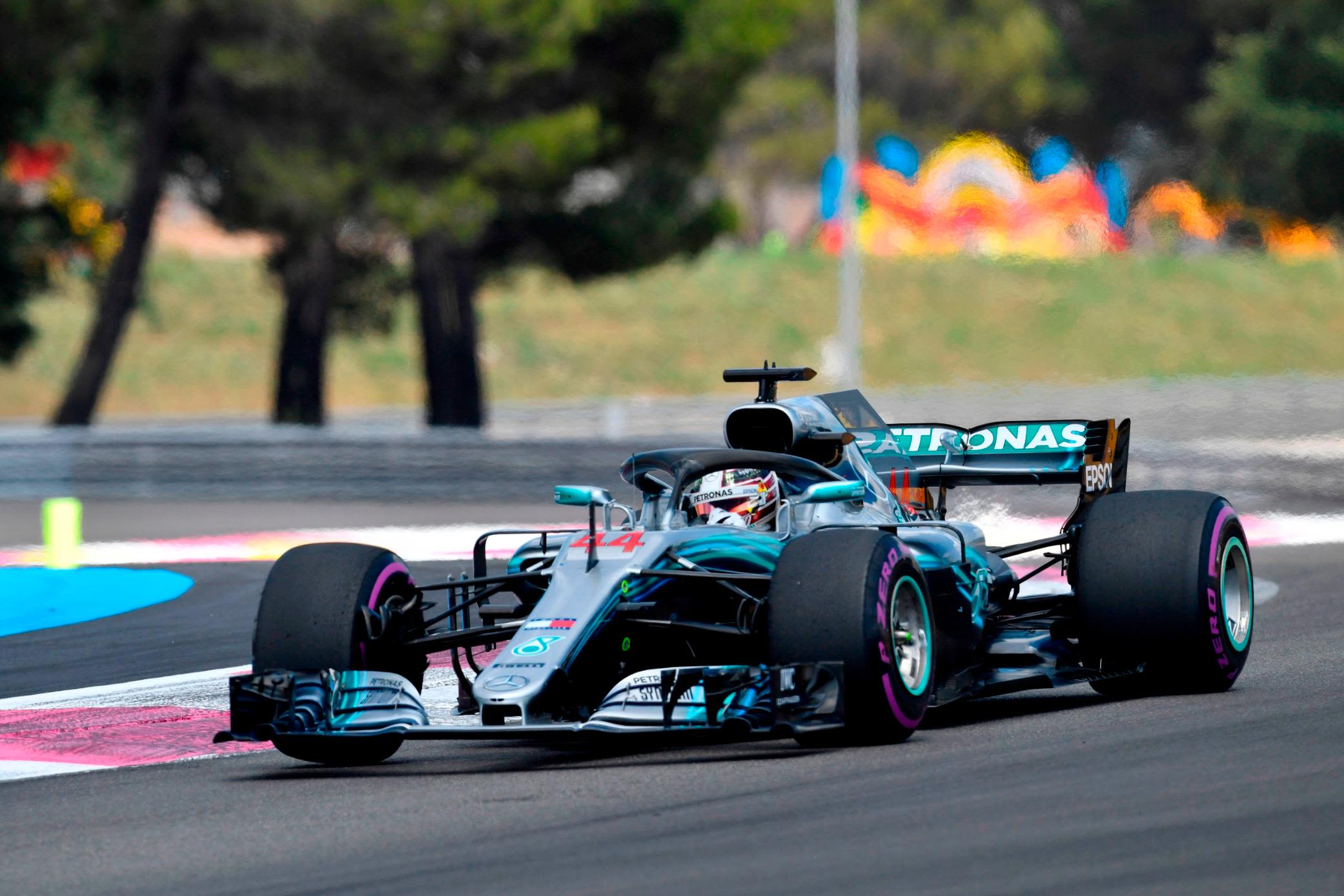 Lewis Hamilton executing a late-braking overtake into a tight corner