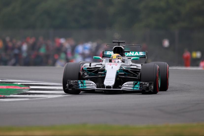 Lewis Hamilton driving through spray in heavy rain, showcasing wet-weather car control