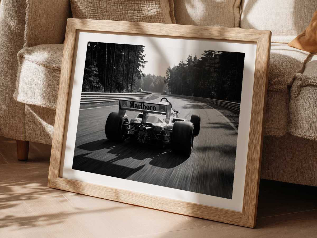 McLaren 1980s car powering down the Montreal straight with crowd-lined barriers and city skyline in soft focus