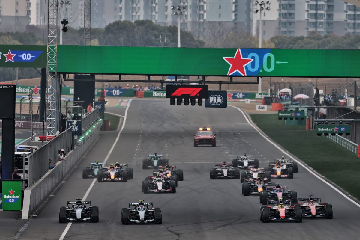 Kimi Antonelli raising his helmet in celebration after crossing the finish line at the 2026 Chinese Grand Prix in Shanghai