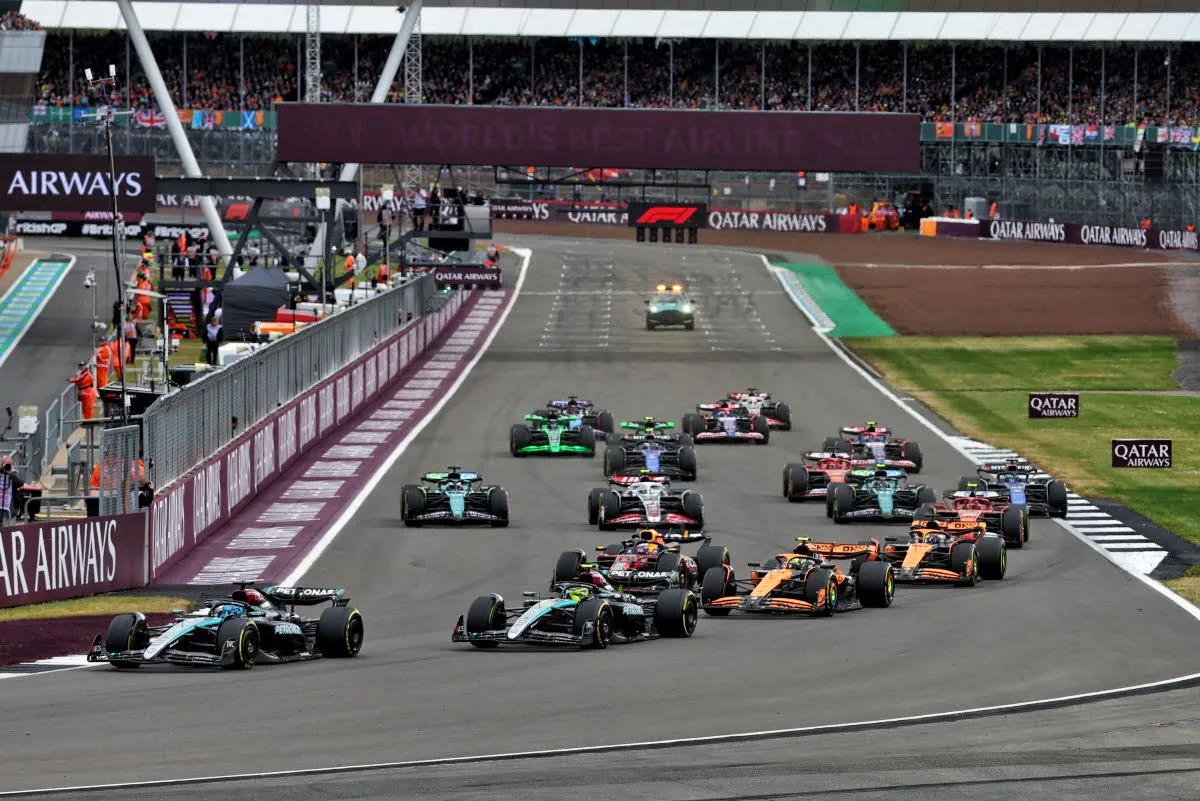High-speed sequence of Formula 1 cars flowing through Silverstone's fast corners under clear skies