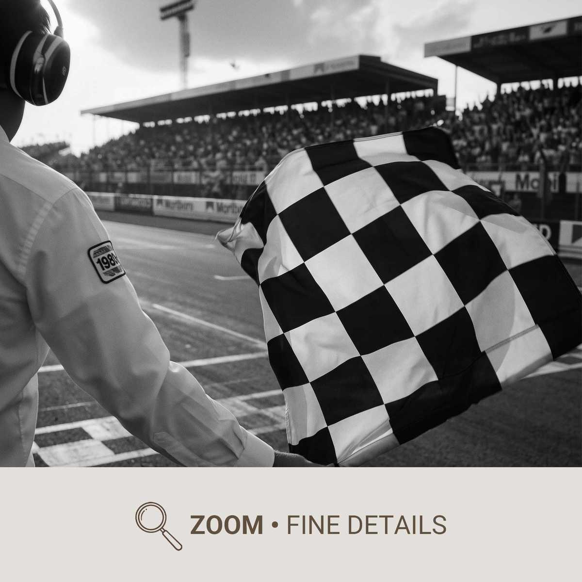 Close-up of a checkered flag waving as a car crosses the finish line, dust and motion blur conveying tension