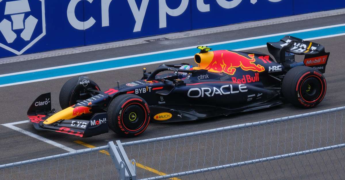 Red Bull driver tightening helmet visor before practice session